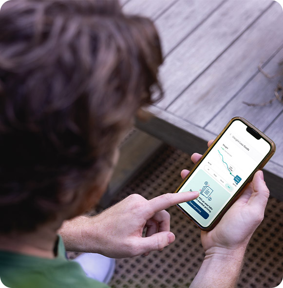 A man looks at his weight loss goals on the phone