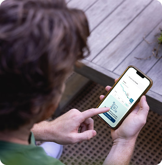 A man looks at his weight loss goals on the phone